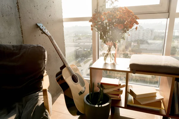 Close up view of acoustic guitar and beautiful bouquet of flowers at window — Stock Photo