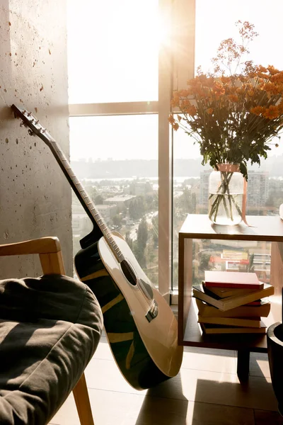 Close up view of acoustic guitar and beautiful bouquet of flowers at window — Stock Photo