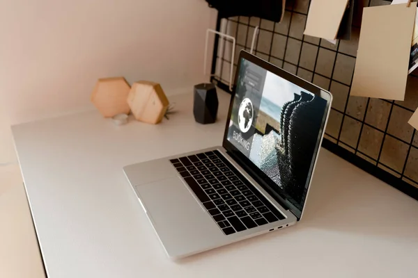 Nahaufnahme des digitalen Laptops mit Buchungslogo auf der Tischplatte zu Hause — Stockfoto