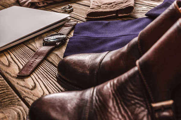 Close up view of laptop, leather male shoes and clothing on wooden tabletop — Stock Photo