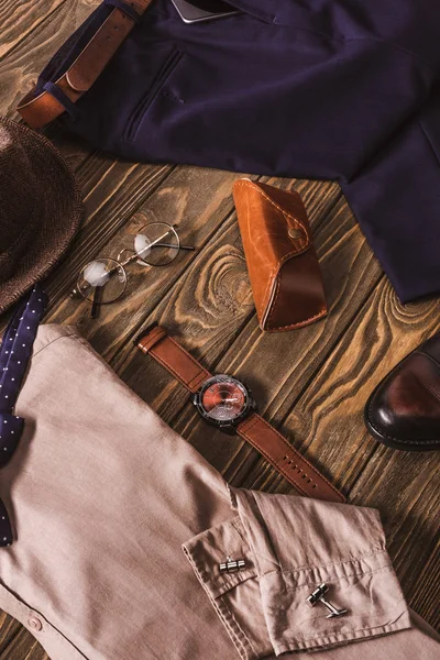 Vista de perto do arranjo de roupas elegantes masculinas e acessórios na mesa de madeira — Fotografia de Stock