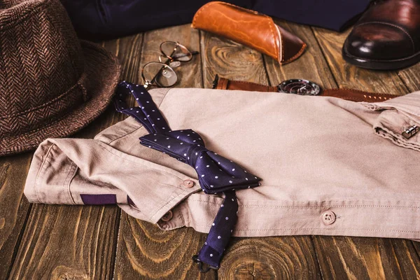 Vista ravvicinata della disposizione della camicia maschile e degli accessori su un tavolo di legno — Foto stock