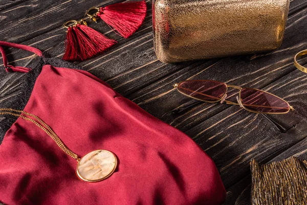 Close up view of red and golden feminine accessories on wooden surface — Stock Photo