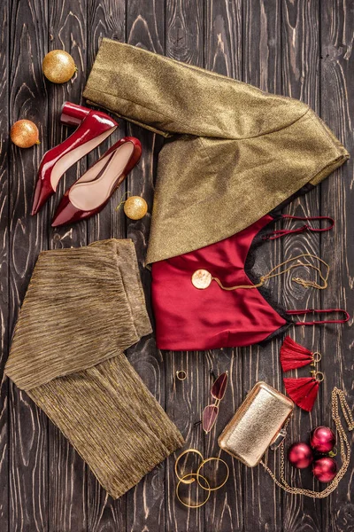 Pose plate avec arrangement de vêtements féminins à la mode, chaussures et accessoires sur la surface en bois — Photo de stock