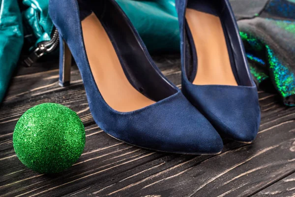Vista da vicino di scarpe blu femminili luminose e palla verde chirstmas sulla superficie di legno — Foto stock