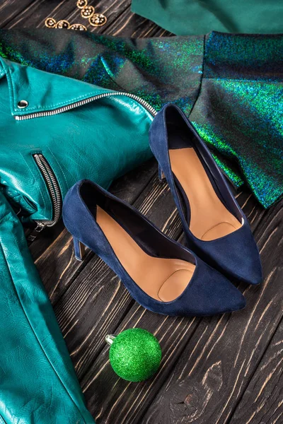 Vue rapprochée de chaussures féminines lumineuses, veste bleue et boucles d'oreilles sur la surface en bois — Photo de stock