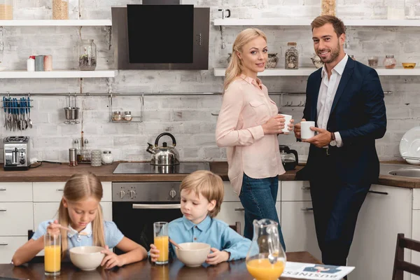 Casual jovem família tomando café da manhã juntos na cozinha — Fotografia de Stock