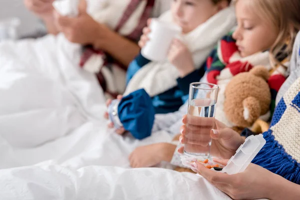 Schnappschuss von kranker junger Familie, die zusammen im Bett sitzt — Stockfoto