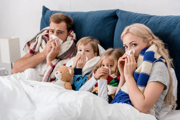 Sick young family lying in bed — Stock Photo