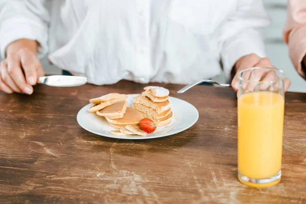Cropped shot of woman eating pancakes with strawberry — Stock Photo