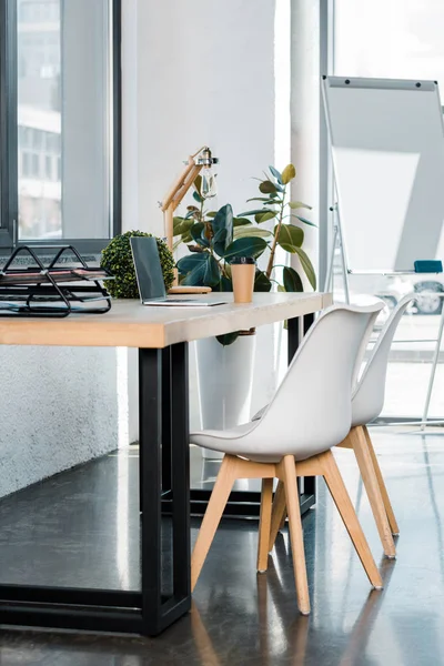 Ordinateur portable et café dans une tasse en papier sur une table en bois dans un bureau — Photo de stock