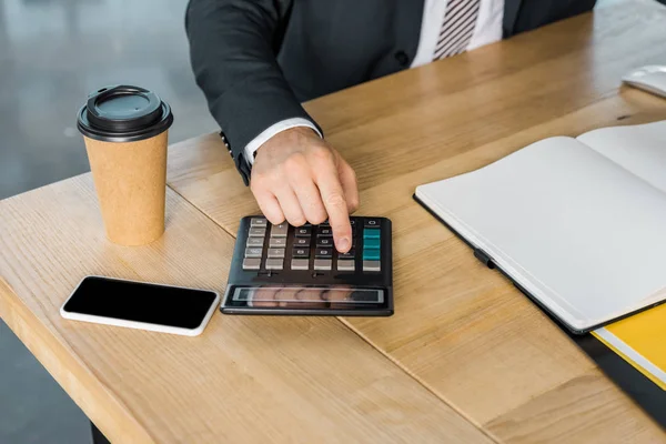 Image recadrée de l'homme d'affaires à l'aide d'une calculatrice pendant le travail au bureau — Photo de stock