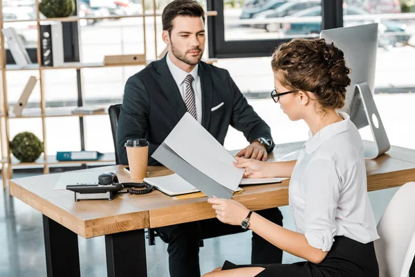 Uomo d'affari e socio d'affari con documenti che discutono il lavoro sul posto di lavoro in ufficio — Foto stock