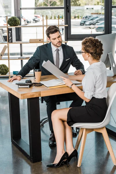 Empresario y socio comercial con documentos que discuten el trabajo en el lugar de trabajo en la oficina - foto de stock