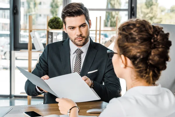 Uomo d'affari e socio d'affari con documenti che discutono il lavoro sul posto di lavoro in ufficio — Foto stock