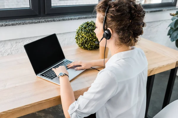 Young female call center operator with headset at workplace in office — Stock Photo