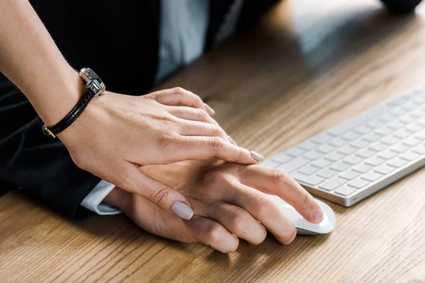 Cropped shot of businesswoman holding colleagues hand while flirting — Stock Photo