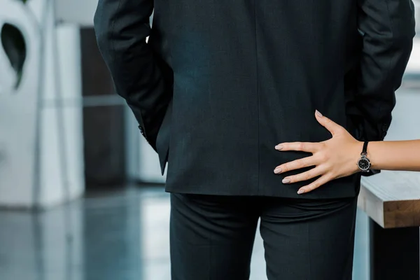 Recortado disparo de mujer de negocios coqueteando con colega en la oficina - foto de stock