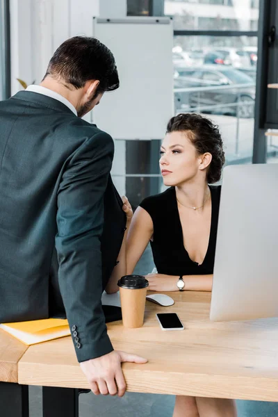 Joven mujer de negocios seductora coqueteando con colega en el lugar de trabajo en la oficina - foto de stock