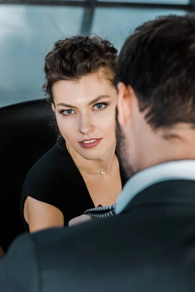 Partial view of businesswoman holding businessmans tie while flirting — Stock Photo