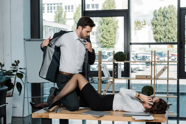 Passionate businessman and businesswoman on table in office — Stock Photo