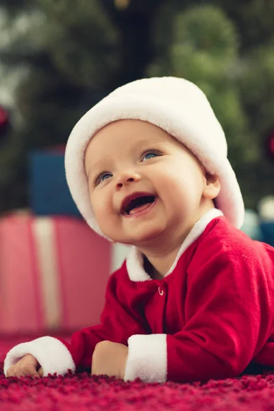 Portrait en gros plan d'adorable petit bébé en chapeau de Père Noël regardant vers le haut — Photo de stock