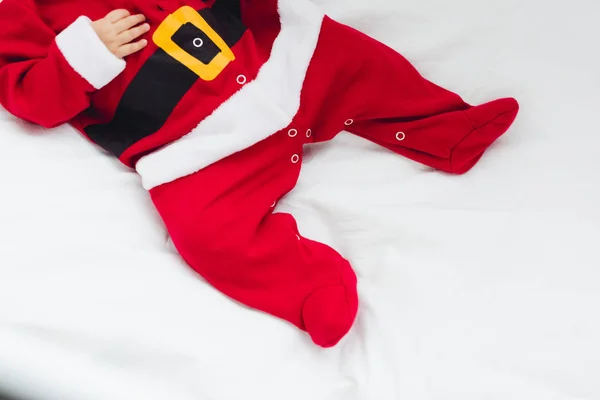 Schnappschuss eines kleinen Babys im Weihnachtsmannanzug, das im Bett liegt — Stockfoto
