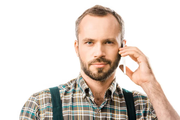 Retrato de fontanero guapo hablando por teléfono inteligente y mirando la cámara aislada en blanco - foto de stock