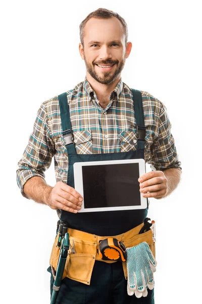 Handsome smiling plumber showing tablet with blank screen isolated on white — Stock Photo