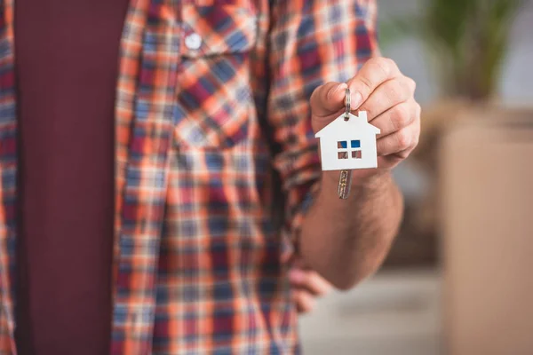 Primer plano vista parcial del hombre sosteniendo la llave de la nueva casa - foto de stock