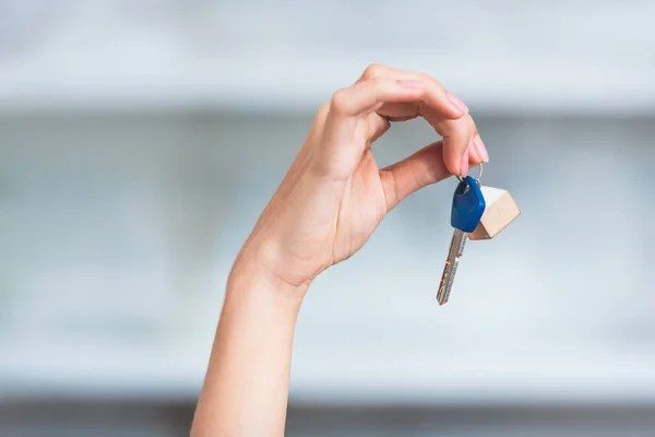 Primer plano vista parcial de la joven mujer sosteniendo la llave de nuevo hogar - foto de stock