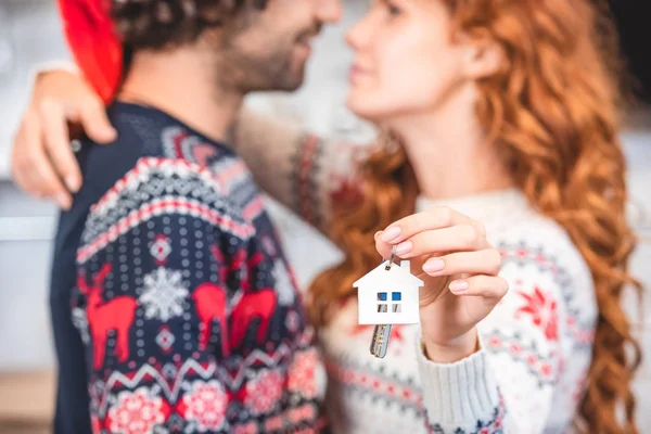 Close-up view of happy young couple hugging and holding keys from new home — Stock Photo