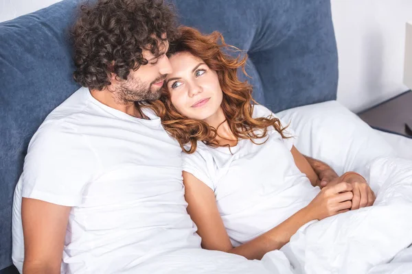 Vista de ángulo alto de hermosa pareja joven feliz acostados juntos en la cama - foto de stock