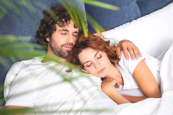 Вид под высоким углом на красивую молодую пару, спящую вместе в постели — стоковое фото