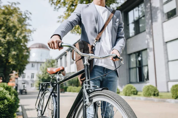 Cropped view of stylish man walking with bicycle in city — Stock Photo