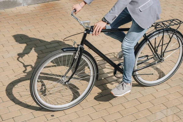 Cropped view of young stylish man riding bicycle in city — Stock Photo