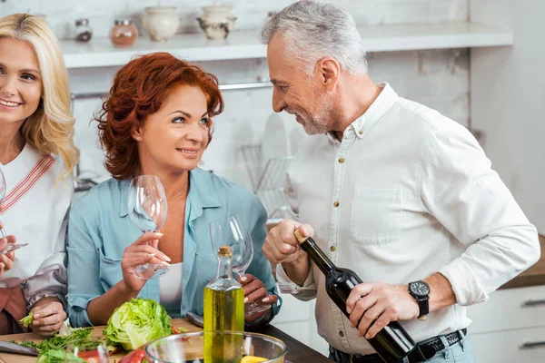 Lächelndes älteres Paar schaut sich bei Freundschaftstreffen zu Hause an — Stockfoto