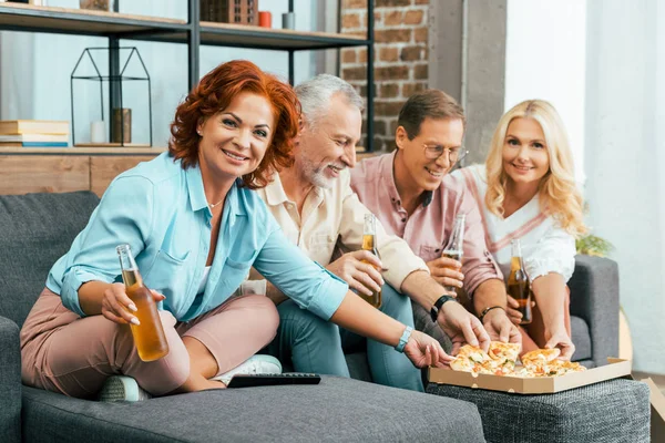 Velhos amigos felizes bebendo cerveja e comendo pizza enquanto passam o tempo juntos em casa — Fotografia de Stock