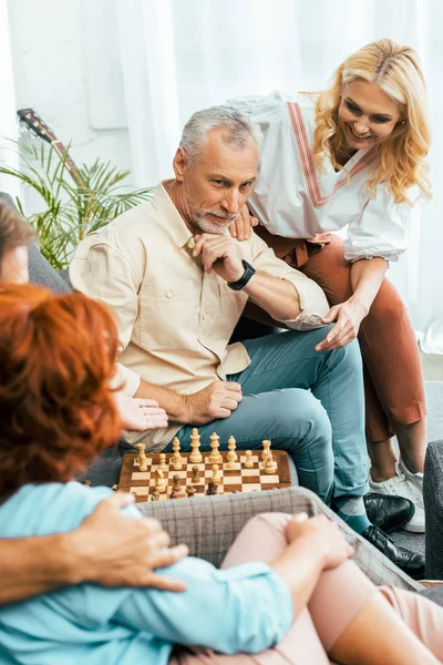 Обрезанный снимок счастливых старых друзей, проводящих время вместе и играющих в шахматы дома — стоковое фото