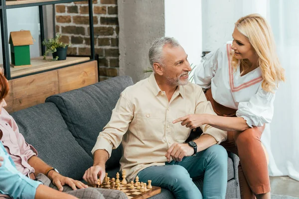 Amici maturi felici trascorrere del tempo insieme e giocare a scacchi a casa — Foto stock