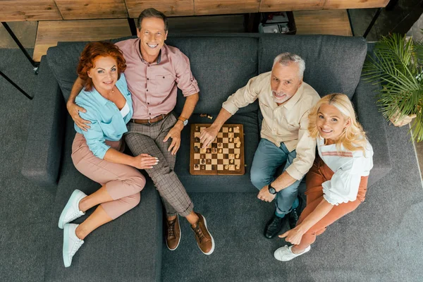 Vista aerea di amici maturi che giocano a scacchi e sorridono alla fotocamera — Foto stock