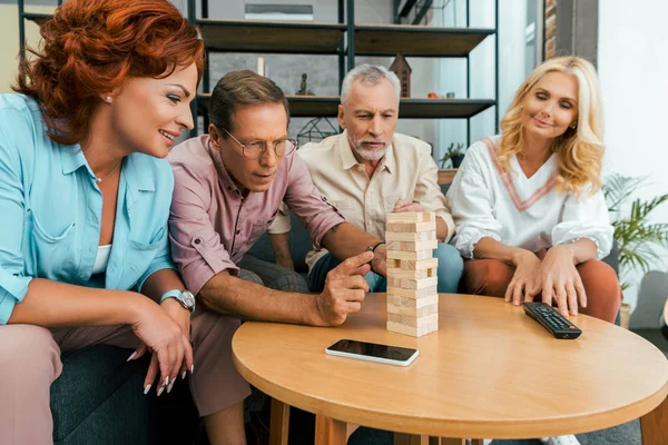 Old friends spending time together and playing with wooden blocks at home — Stock Photo