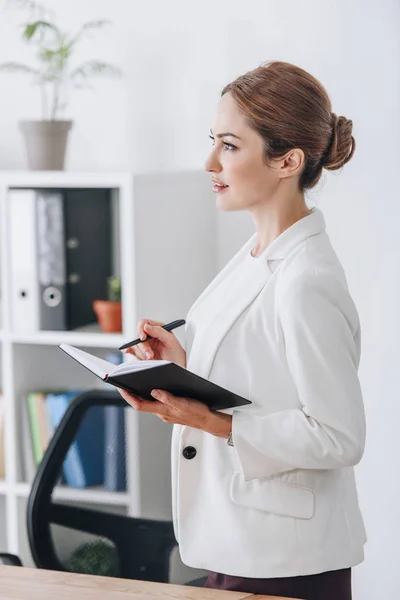 Executive business woman working with diary in modern office — Stock Photo