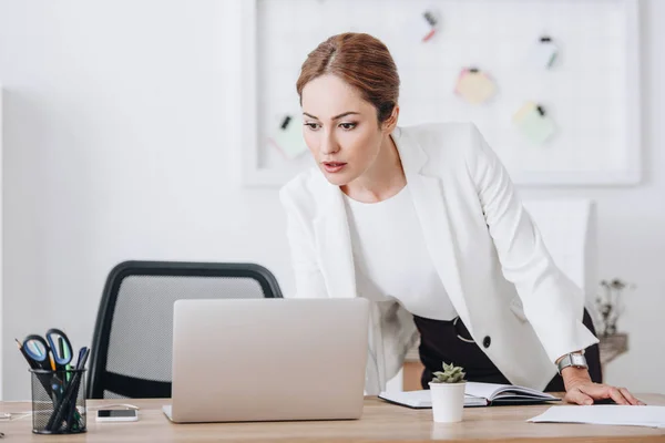 Geschäftsfrau arbeitet am Arbeitsplatz mit Tagebuch und Laptop — Stockfoto