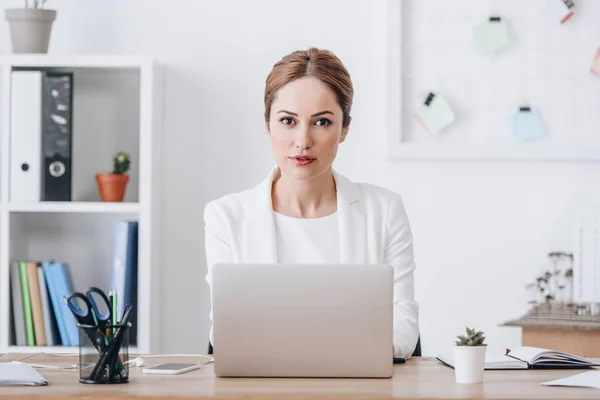 Впевнена бізнес-леді в офісному одязі, що працює з ноутбуком — стокове фото