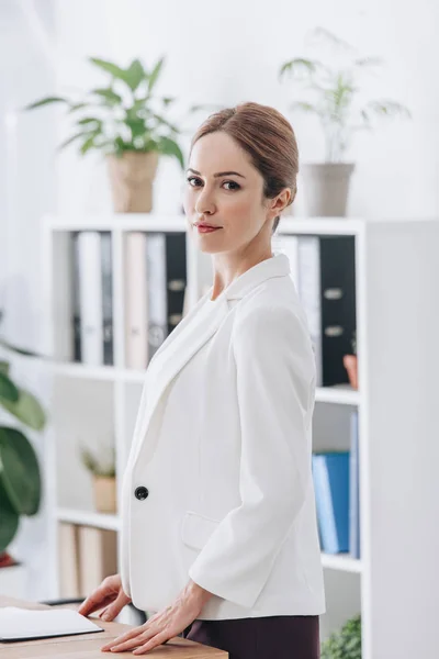 Hermosa mujer de negocios confiada en el desgaste formal posando en la oficina - foto de stock