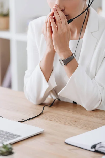 Cropped view of worried operator working with headset in call center — Stock Photo