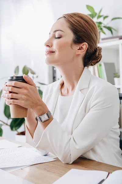 Attractive businesswoman rest with closed eyes and holding coffee to go in office on coffee break — Stock Photo