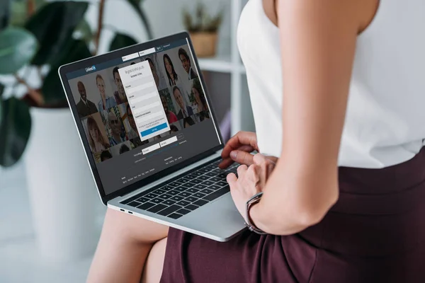 Cropped view of businesswoman using laptop with linkedin website — Stock Photo