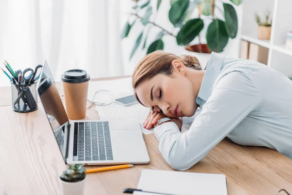 Überarbeitete erwachsene Geschäftsfrau schläft am Arbeitsplatz in modernem Büro — Stockfoto